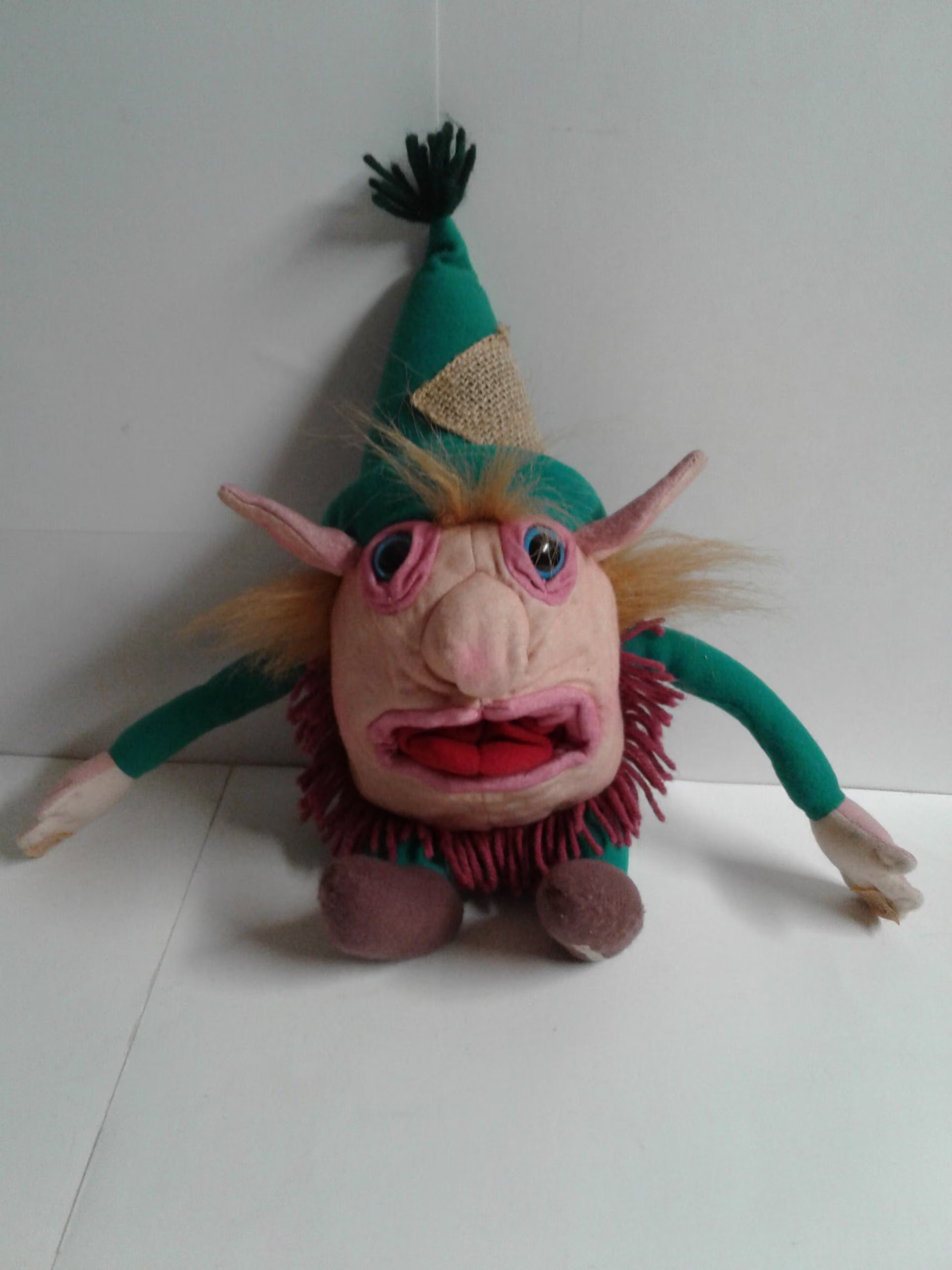 Early Efilist study object featuring felt construction, a green cap, and a strongly asymmetrical face.